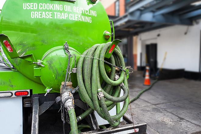 grease trap being pumped out by service technician in Greenacres